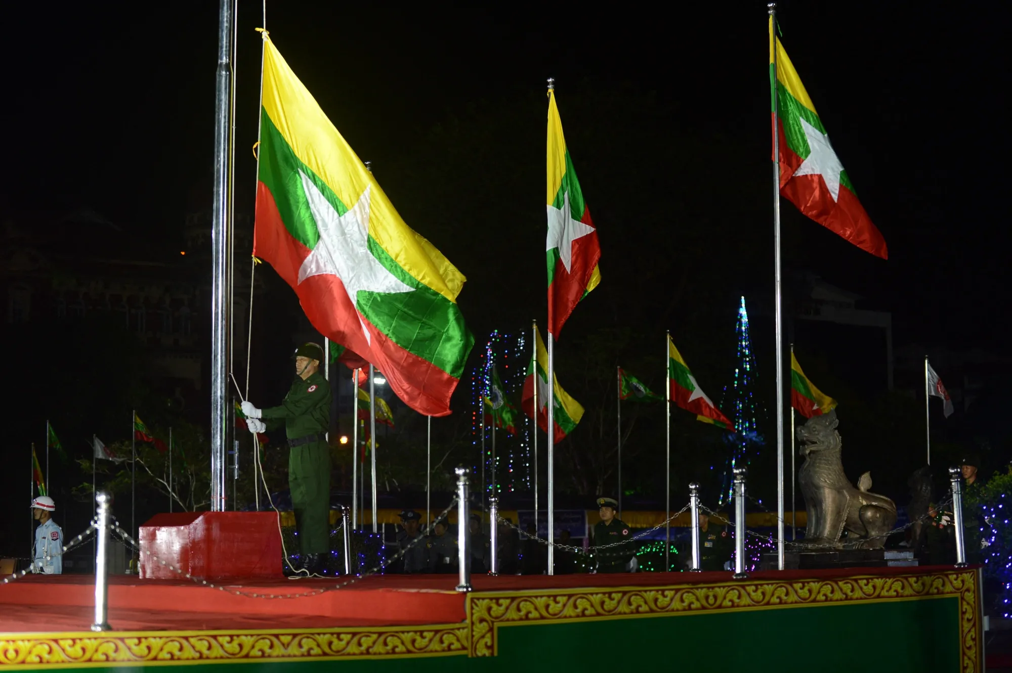 A Myanmar military honour guard raises the national flag in Yangon.