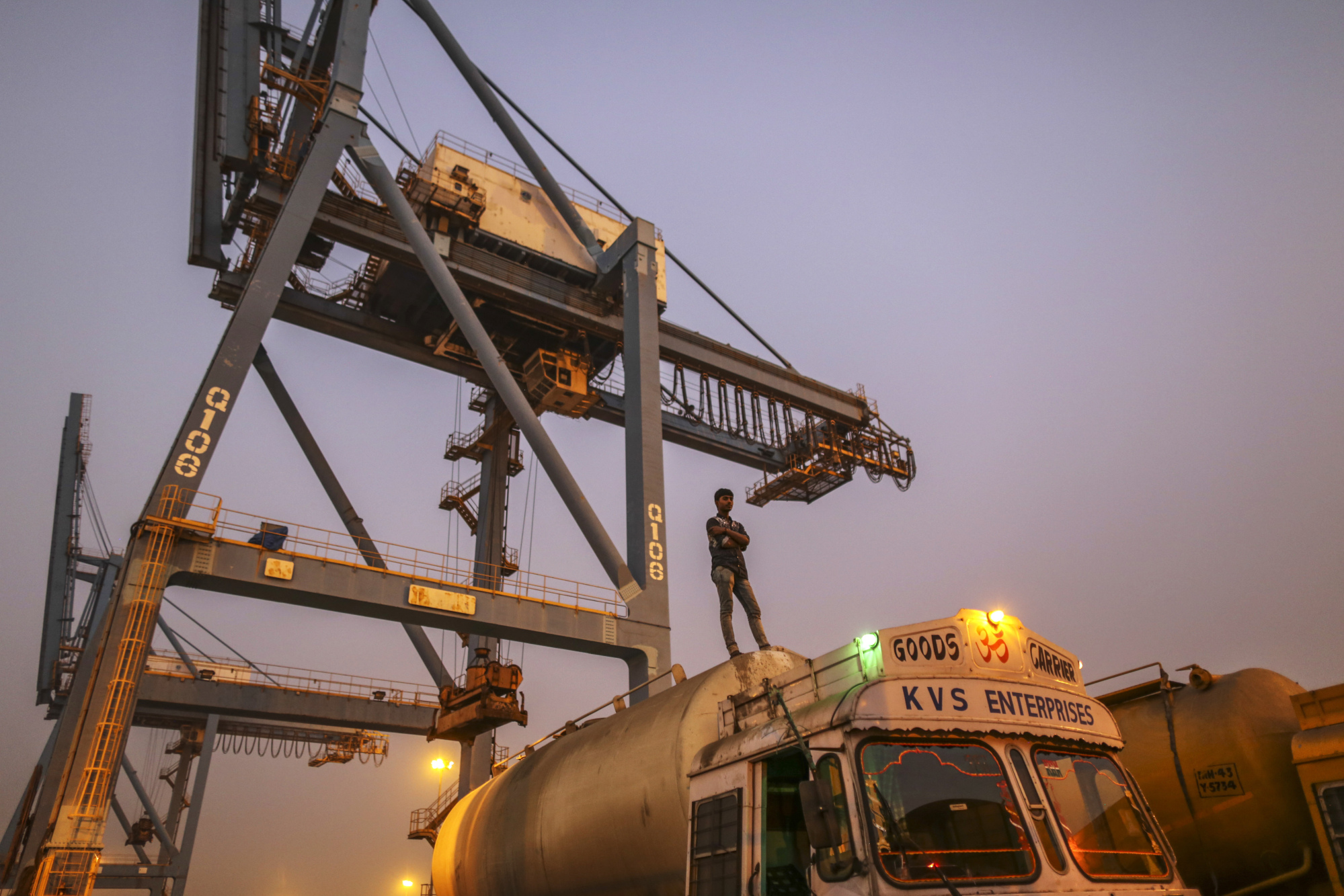A driver stands on a cement tanker truck at the Jawaharlal Nehru Port, operated by Jawaharlal Nehru Port Trust (JNPT), in Navi Mumbai, Maharashtra, India, on Saturday, Dec. 16, 2017. Many of the cargo containers passing through India's busiest port in Mumbai have a small piece of Japan Inc. attached: Devices from NEC Corp. that can be tracked as the containers rumble through the interior of Asia's third-largest economy.