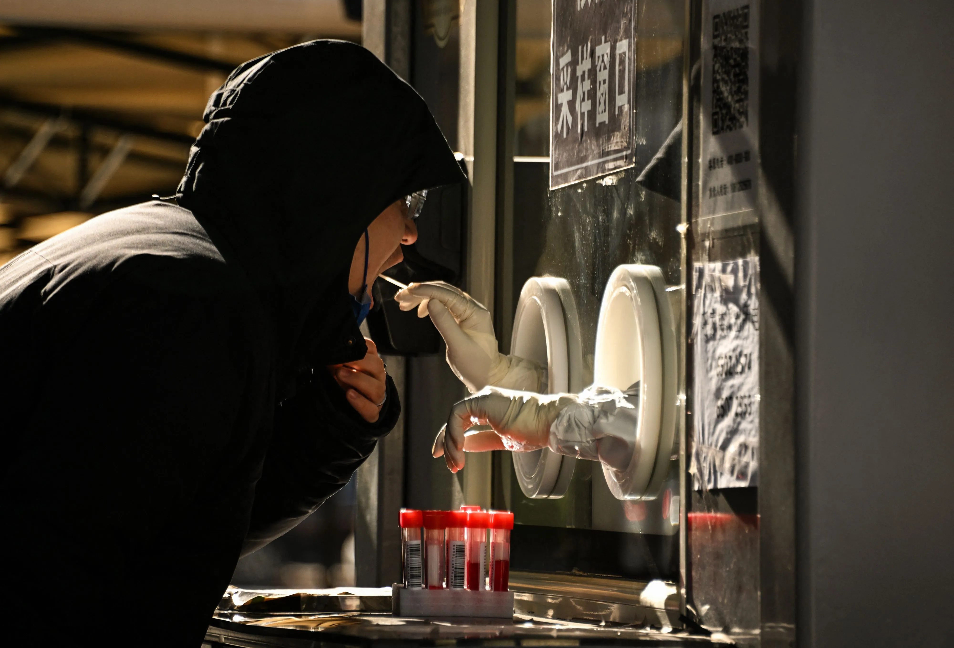 A health worker takes a cheek swab sample.