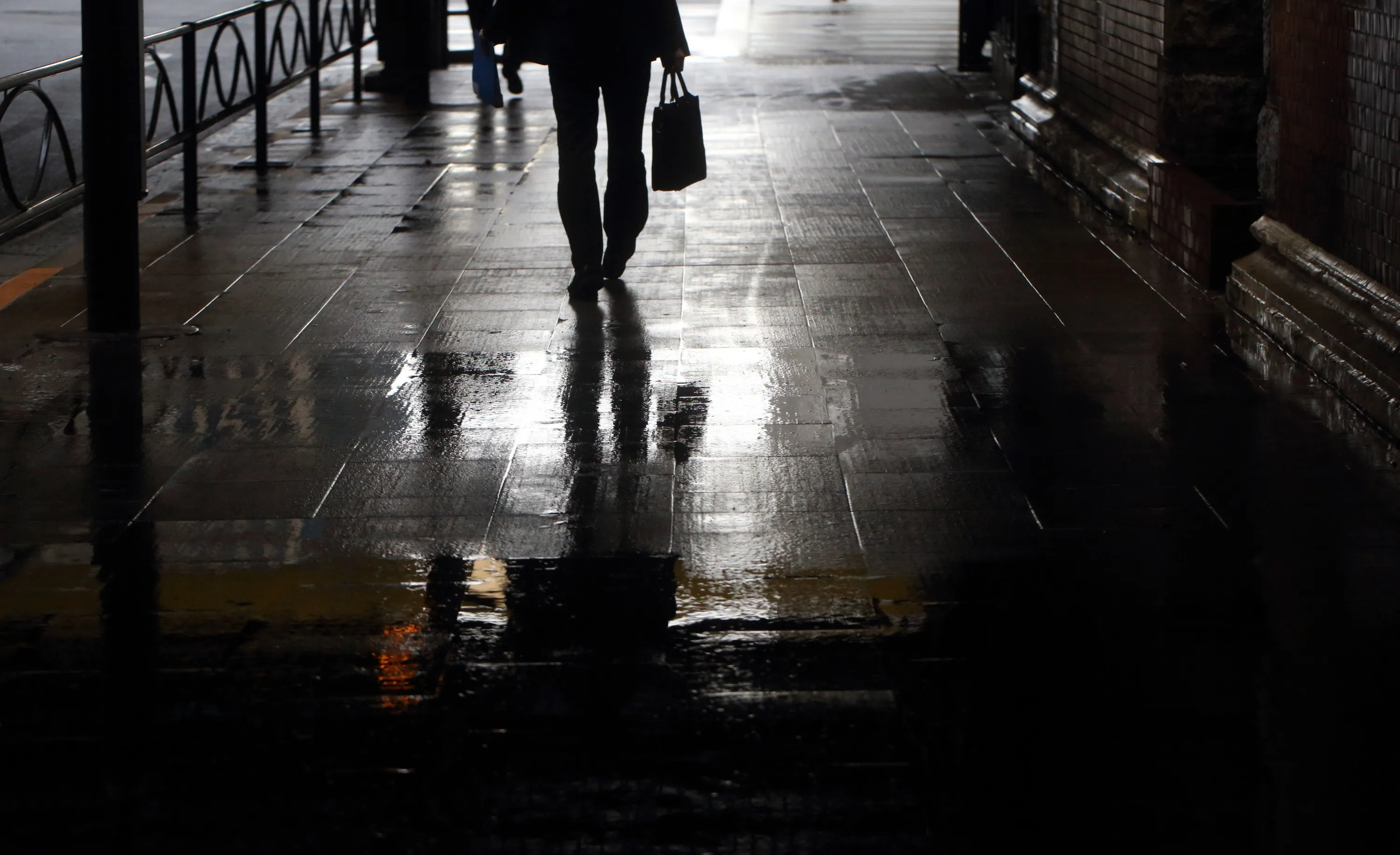 A pedestrian walks along a street as rain falls in Tokyo.