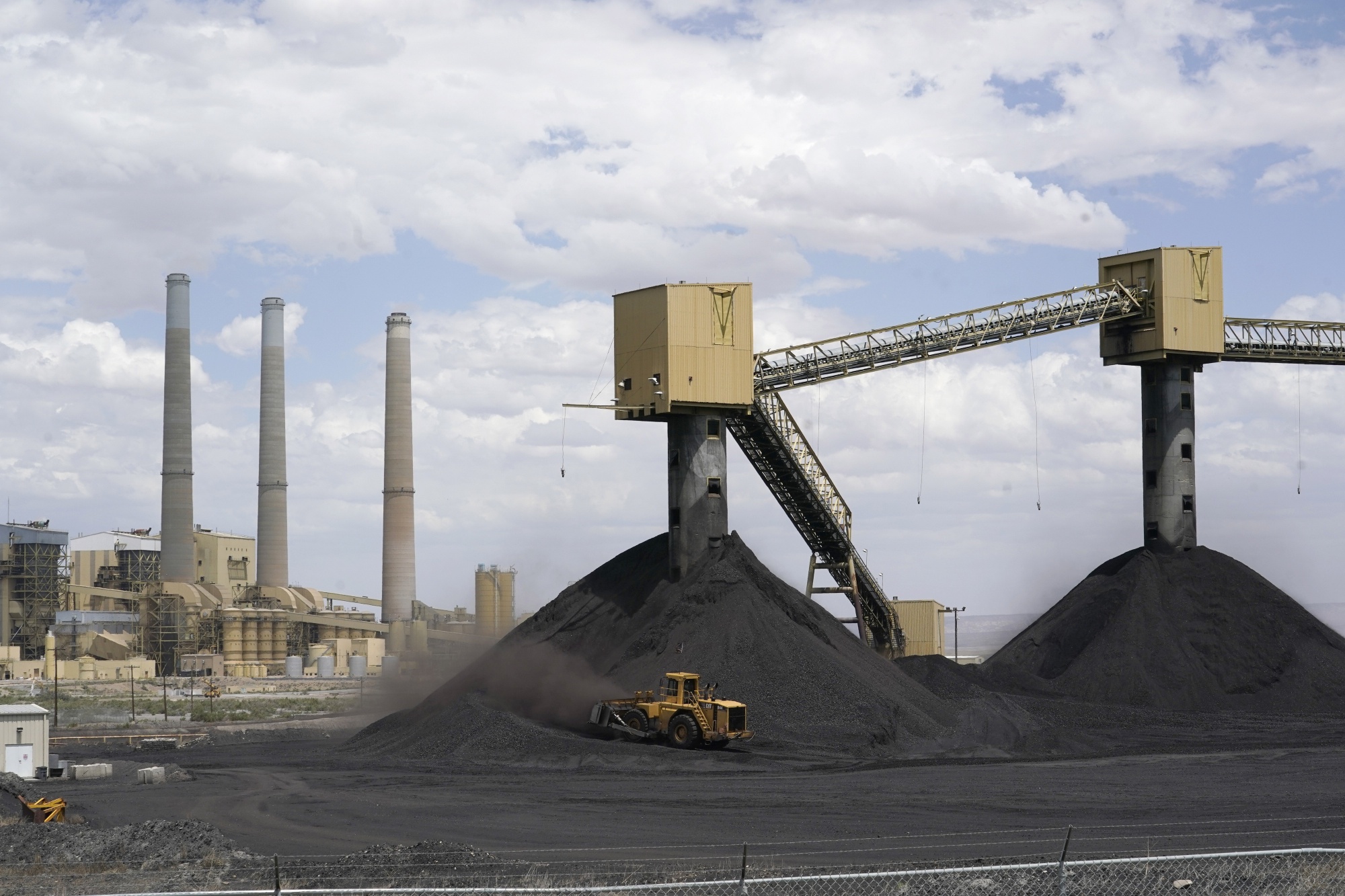 An earth mover pushes coal into piles at a coal-fired electrical generation plant in Castle Dale, Utah.