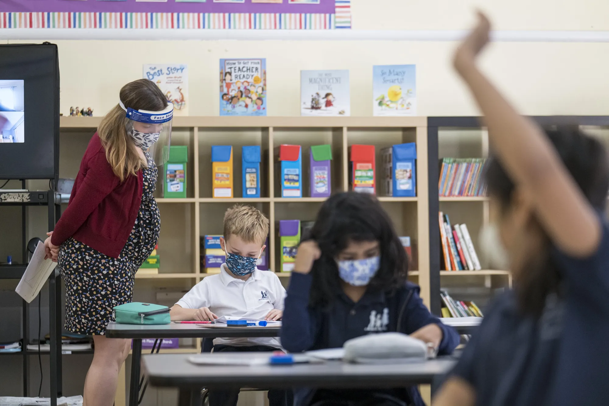 A teacher looks at the work of a student at an elementary school in San Francisco, on Oct. 5.&nbsp;