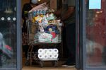 A customer pushes a shopping trolley full of groceries a supermarket in London.