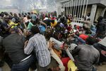 People push through a gate and create a stampede in the Kibera slum of Nairobi on April 10.