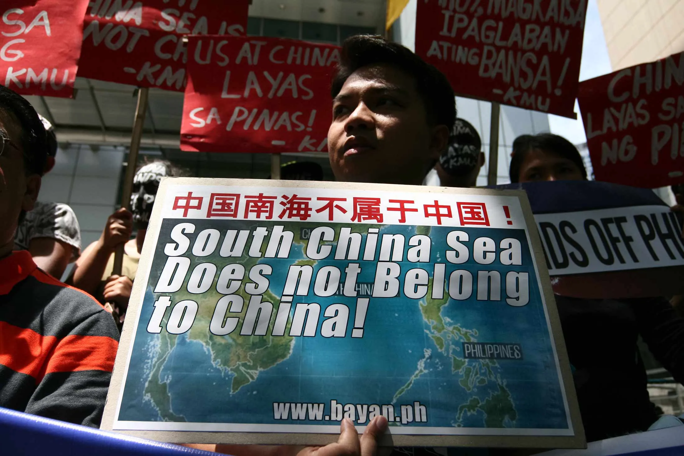 A protester holds a sign reading 'South China Sea Does Not Belong to China!' in Makati, Philippines.
