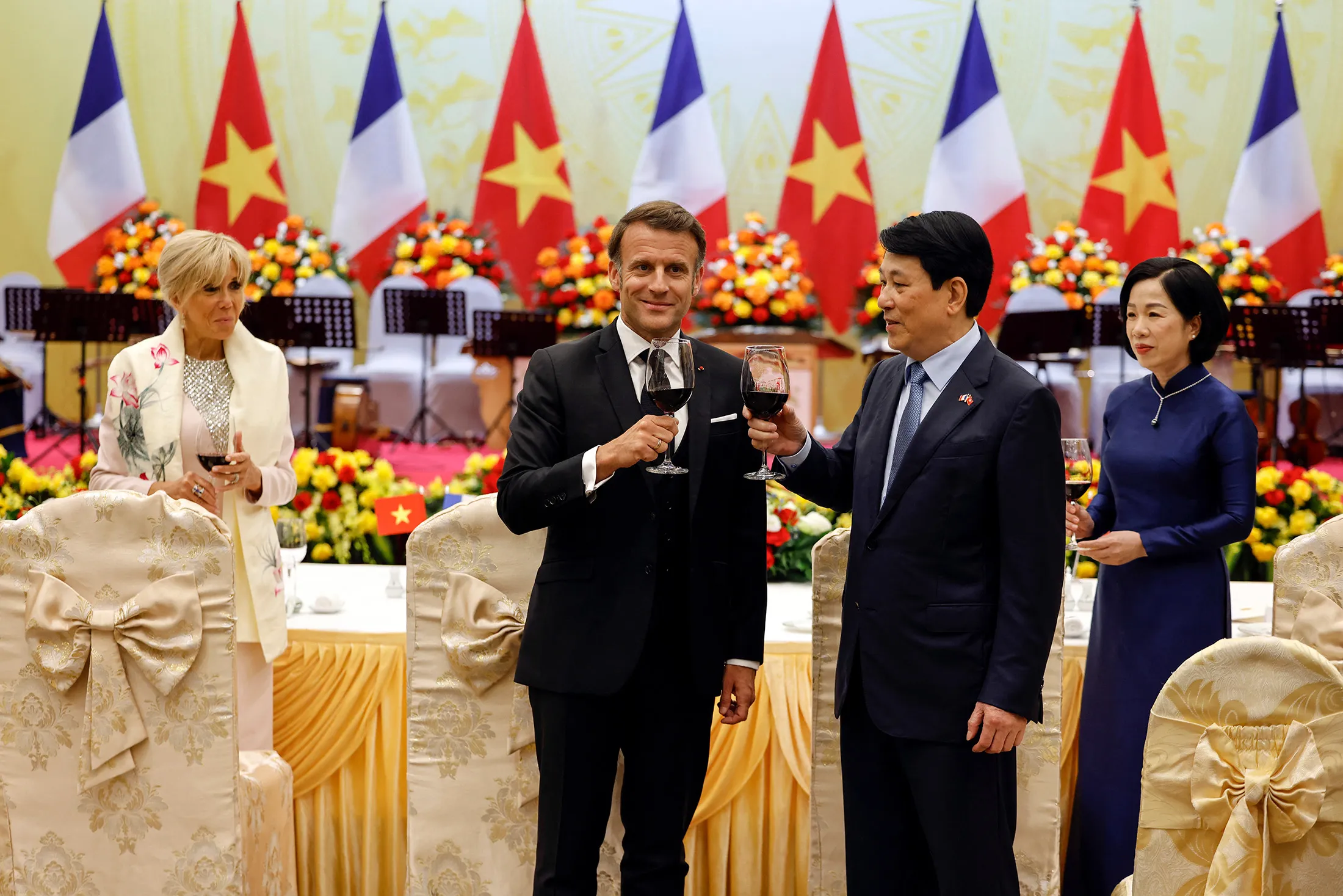 Luong Cuong, second right, raises a toast with Emmanuel Macron during a state dinner in Hanoi on May 26.