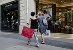 Shoppers pass a Jimmy Choo Plc luxury footwear store in Paris.
