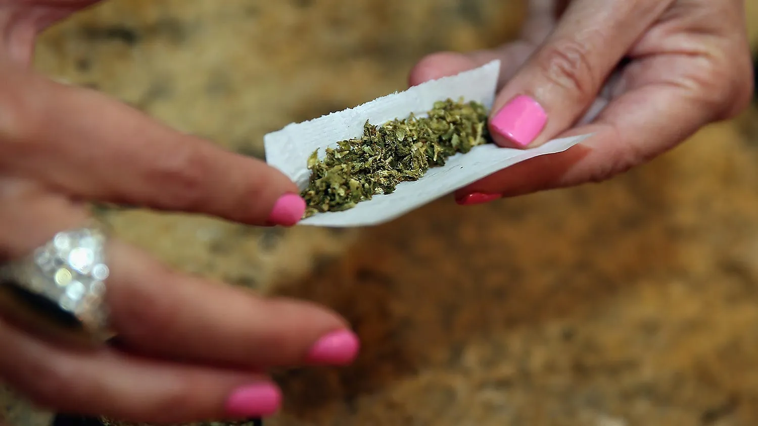 A woman rolls a marijuana cigarette as photographed on August 30, 2014 in Bethpage, New York.
