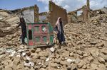 People look for their belongings amid the ruins of a house damaged by an earthquake in Bernal district, Paktika province, on June 23.
