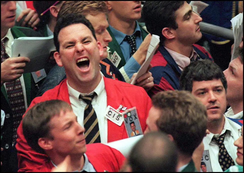 A trader barks instructions from the floor of the
