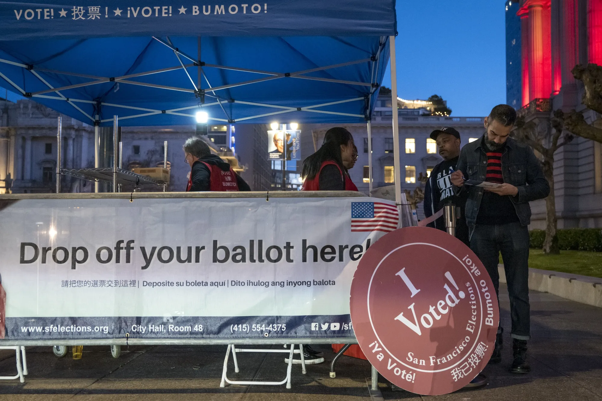 City of San Francisco Department of Elections employees collect mail-in ballots from voters outside City Hall in San Francisco on March 3.