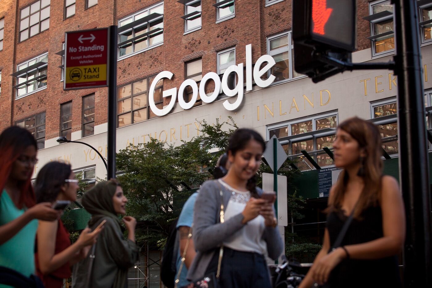 Pedestrians walk past the Google Inc. offices in New York, U.S.