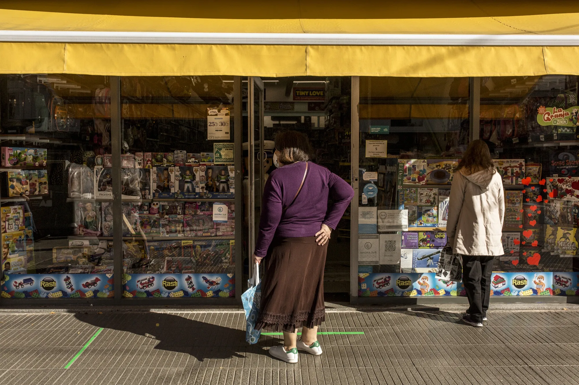 A customer wearing a protective mask waits behind a social distancing marker outside a store in the Belgrano neighborhood of Buenos Aires&nbsp;on May 14.