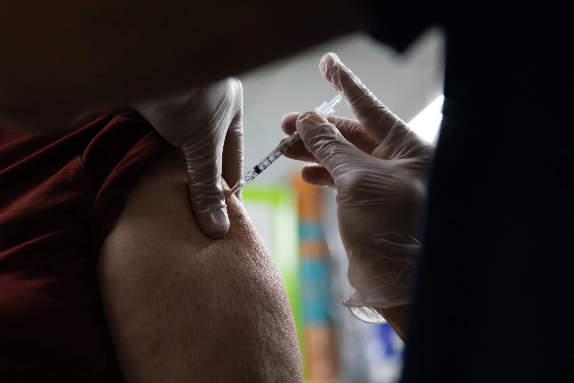 A pharmacist administers a third dose of the Moderna vaccine to a customer at a pharmacy in Livonia, Michigan.