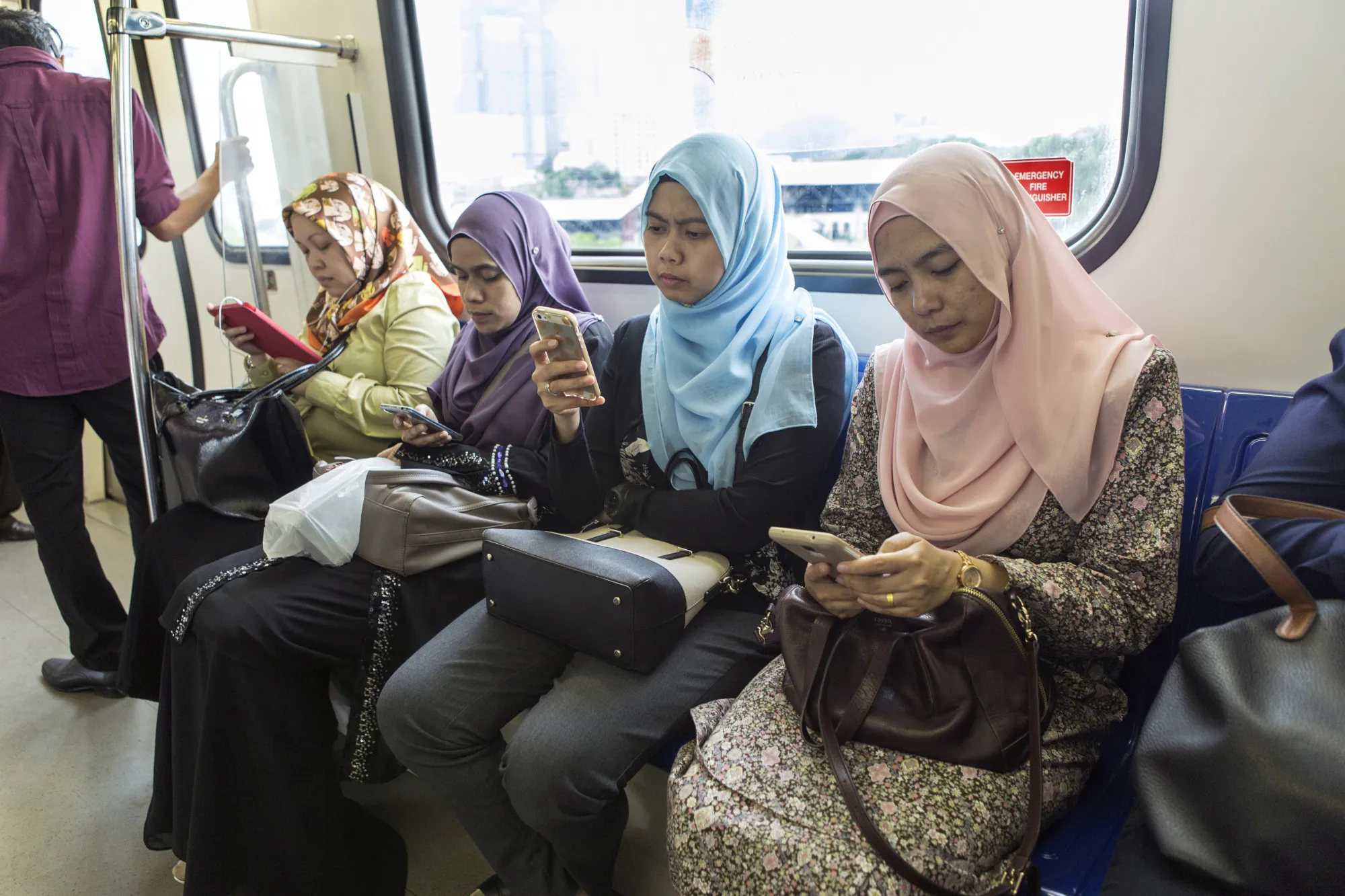 Commuters use mobile devices on an&nbsp;LRT&nbsp;train in Kuala Lumpur.