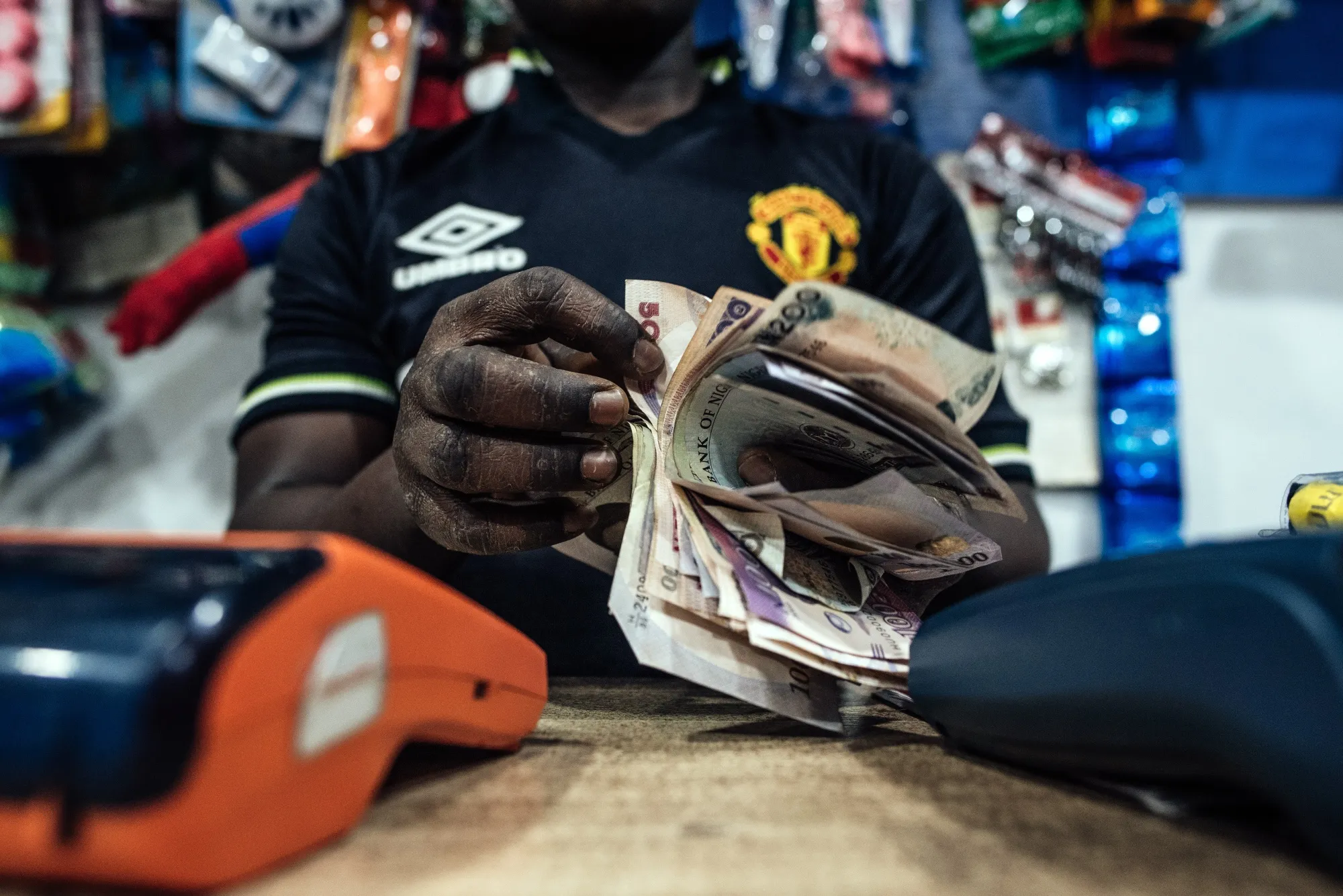 A cashier counts&nbsp;naira banknotes in a store in Abuja.&nbsp;