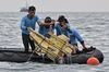 Indonesian Navy divers hold wreckage from Sriwijaya Air flight SJY182 during a search and rescue operation at sea near Lancang island on January 10, 2021, after the Boeing 737-500 crashed shortly after taking off from Jakarta airport on January 9.