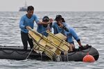 Indonesian Navy divers hold wreckage from Sriwijaya Air flight SJY182 during a search and rescue operation at sea near Lancang island on January 10, 2021, after the Boeing 737-500 crashed shortly after taking off from Jakarta airport on January 9.