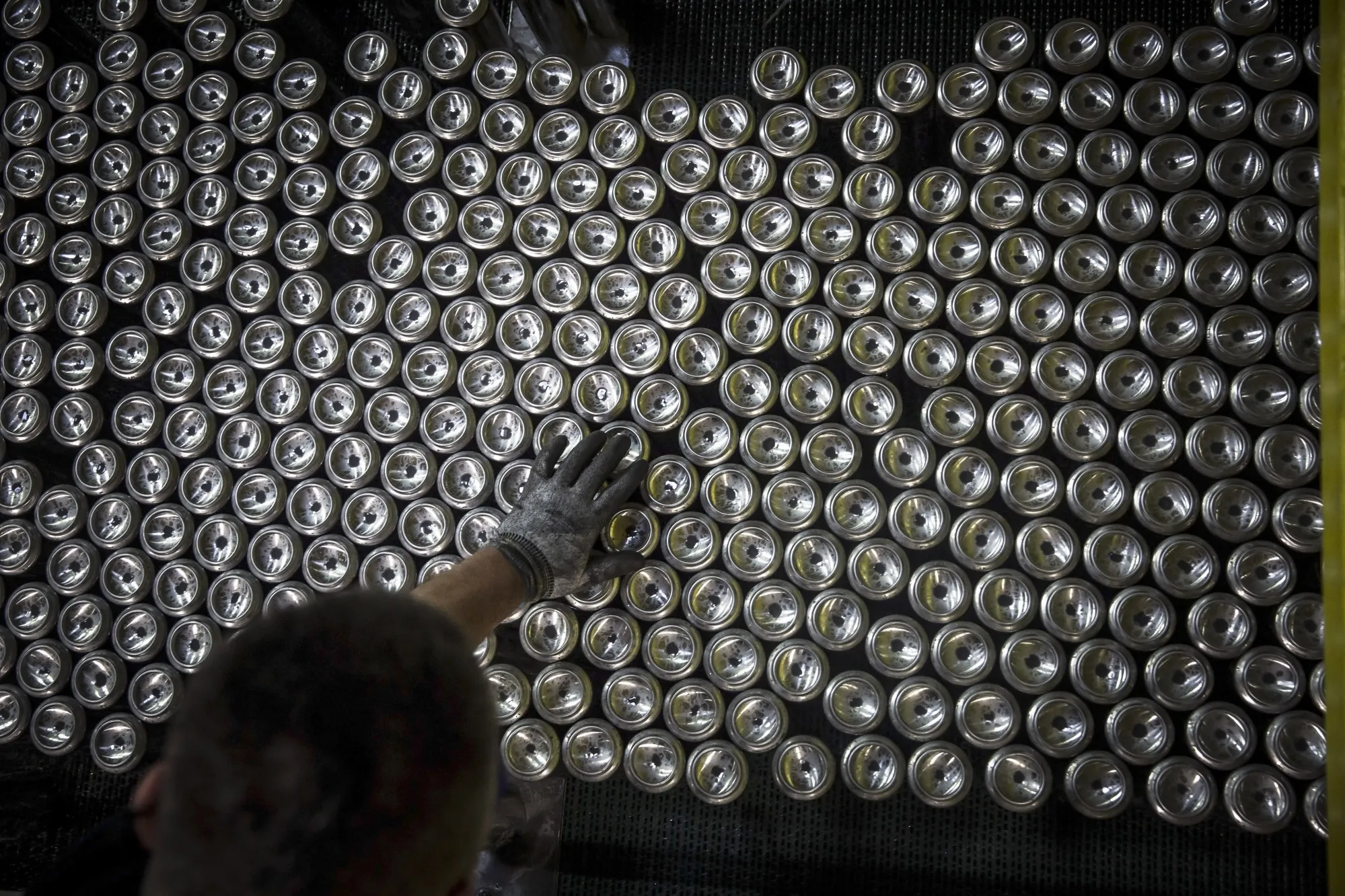 An employee inspects aluminum&nbsp;cans as they pass along the production line at a&nbsp;Ball packaging plant, in Belgrade, Serbia.