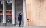 A pedestrian wearing a protective face mask walks past a boarded up&nbsp;store in San Francisco,&nbsp;on&nbsp;&nbsp;March 24.