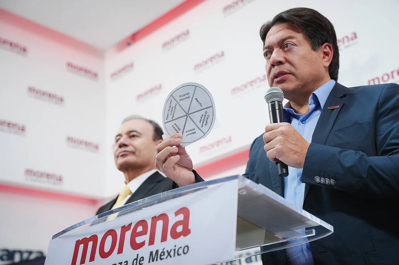 Mario Delgado holds up the round ballot that will be used to determine the party’s nominee for presidential elections.