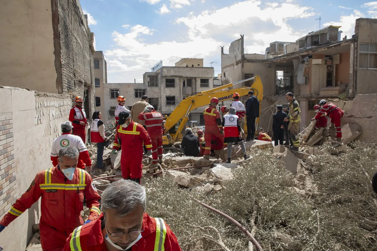 Iranian Red Crescent workers gather near an apartment hit by an airstrike in Tehran on March 30.