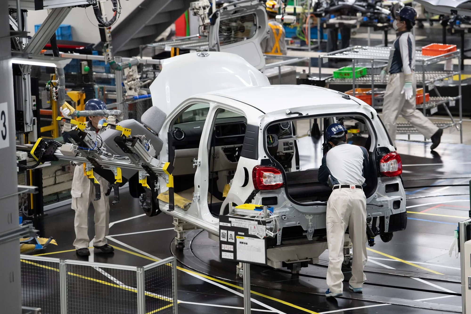 Workers assemble a Toyota Motor Corp. Passo vehicle on the production line at the Daihatsu Motor Co. Kyoto plant.