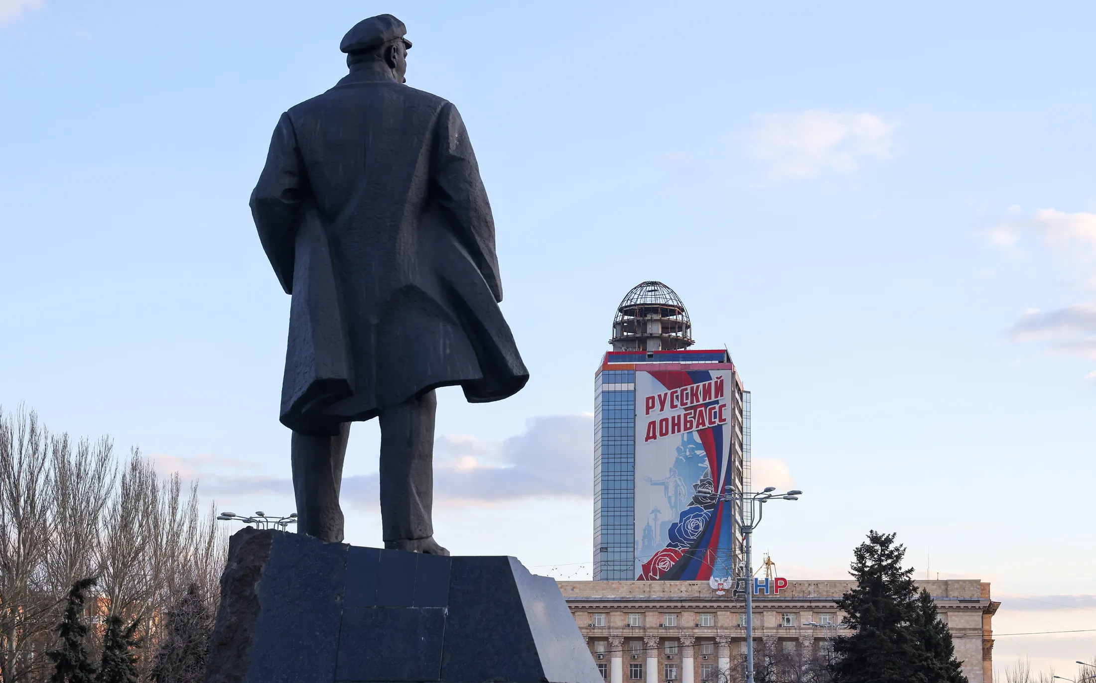 A view of a monument to Russian revolutionary Vladimir Lenin and a poster reading "Russian Donbas."