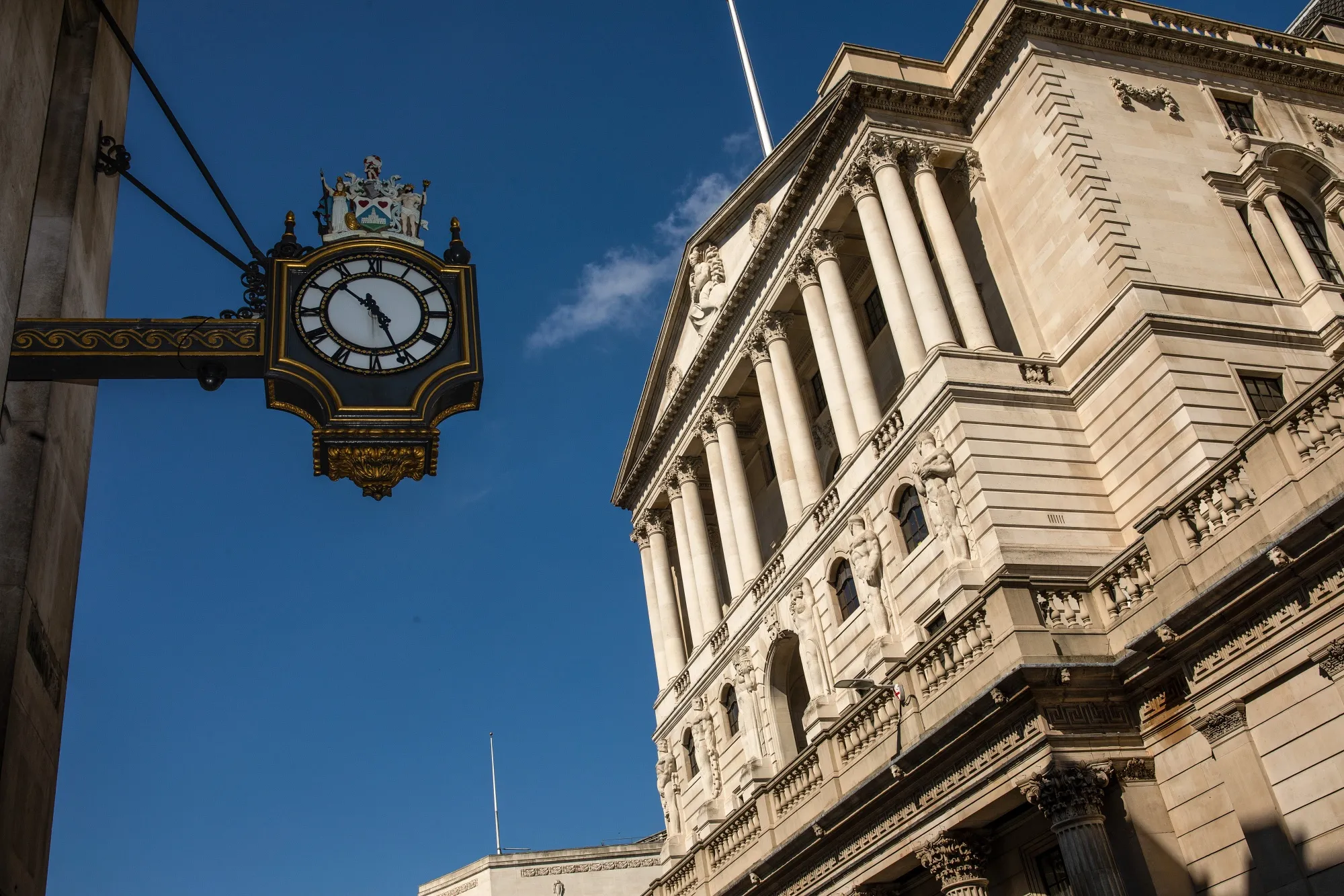 A clock hanging from the Royal Exchange building displays the time in view of the Bank of England (BOE) in London, on May 6.