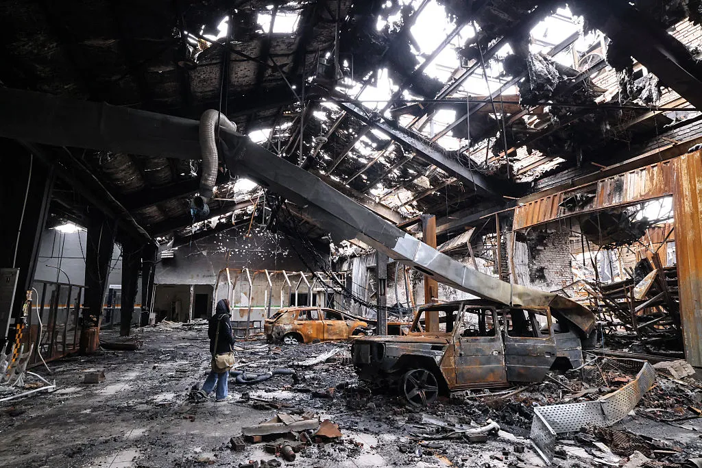 A journalist stands in&nbsp;the wreckage of&nbsp;a car service centre that was hit by a missile strike, in Tehran, on March 28.