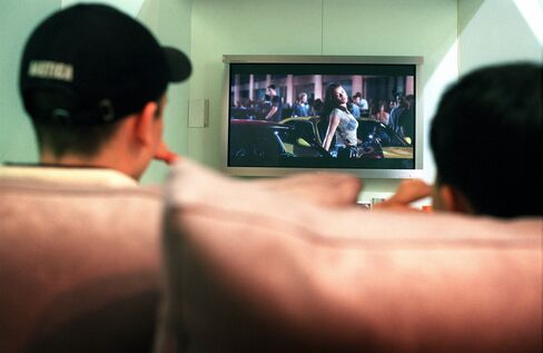 Teenage boys watch a movie on a digital television