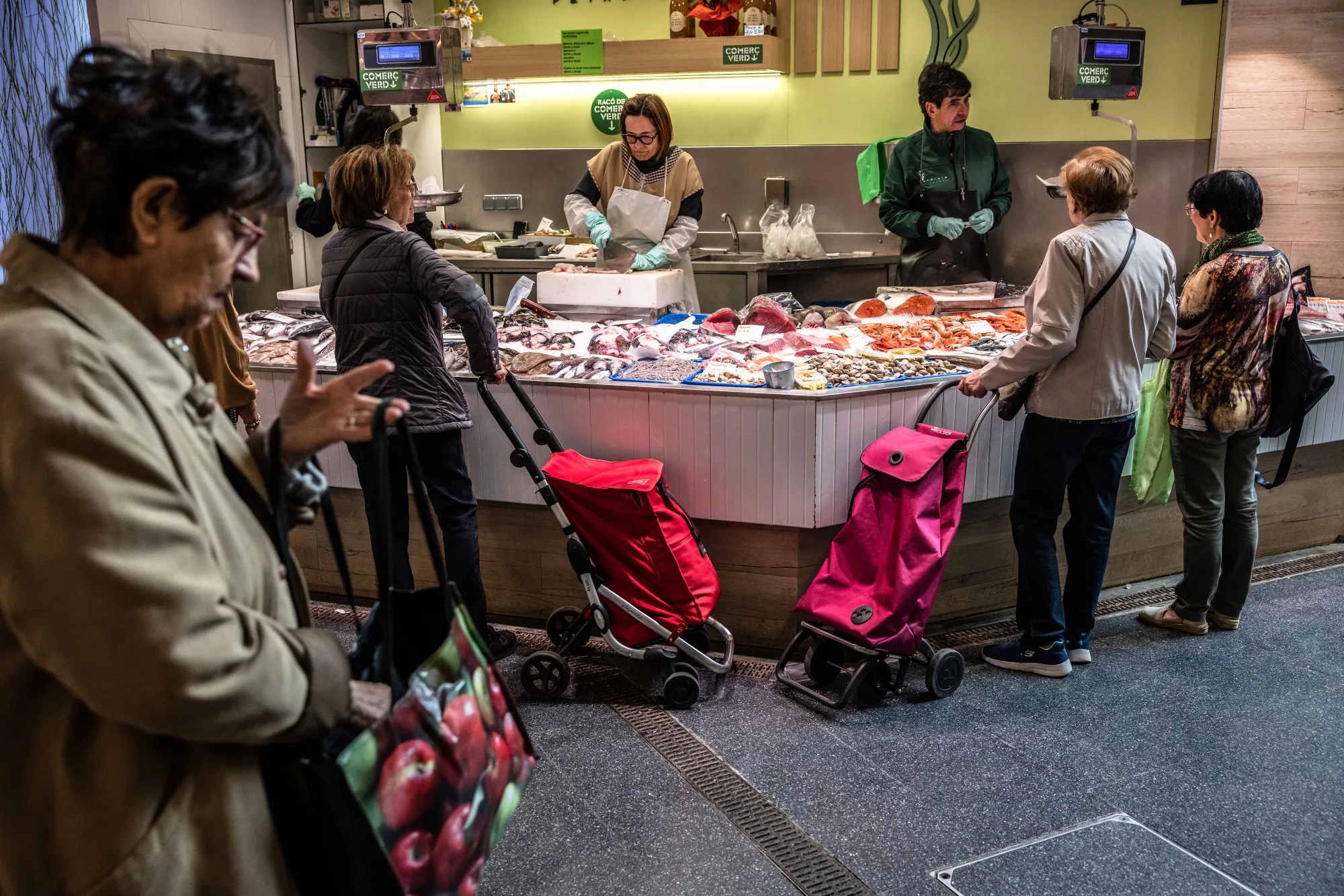 Shoppers at a fishmongers stall in Sant Antoni market in Barcelona, Spain.
