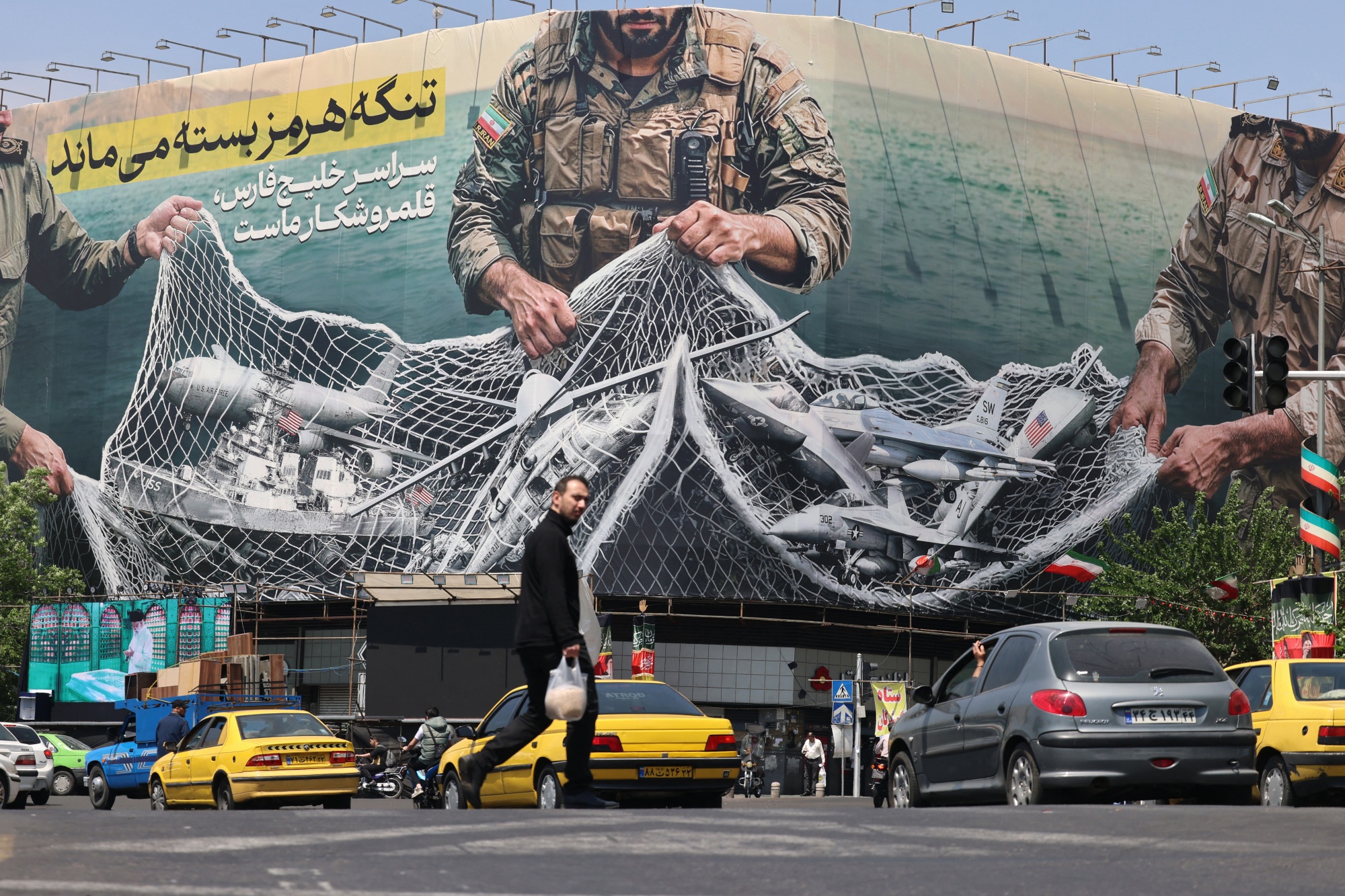Vehicles pass a billboard reading 'The Strait of Hormuz Remains Closed' in Tehran, on April 28. Photographer: Atta Kenare/Getty Images