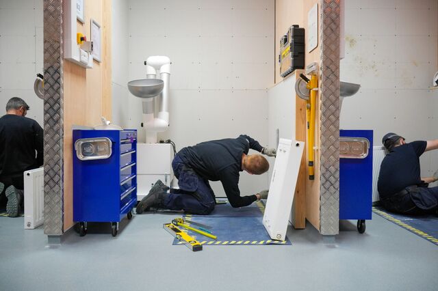 Apprentices hang radiators during a training exercise. Many gas installers will retire before they make the switch to heat pumps — half of those currently working are over the age of 55 — meaning new people need to be trained.