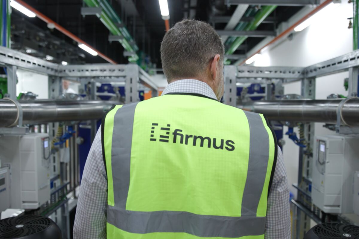 Prospecto de oferta pública recolhido diante de racks de servidores e uma tela financeira