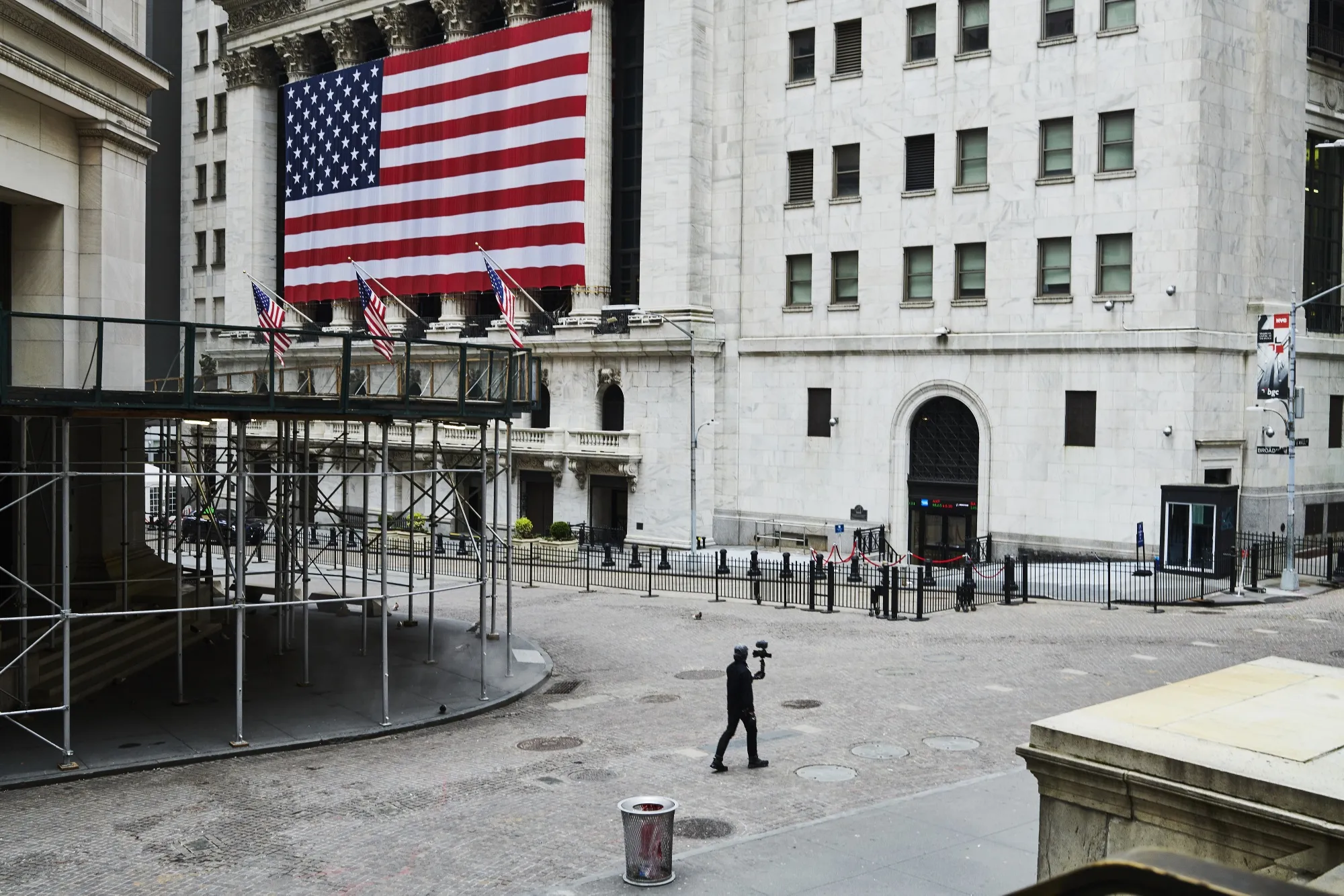 A pedestrian films himself while walking past the New York Stock Exchange on a nearly empty Wall Street in&nbsp;New York.