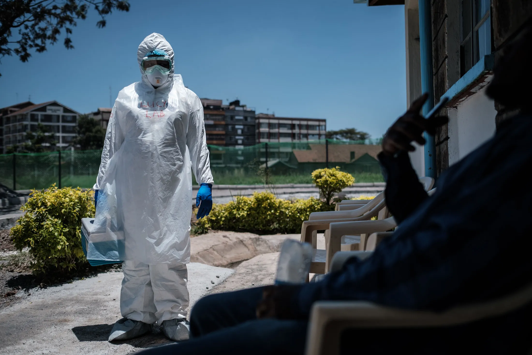 A laboratory specialist wearing protective gear speaks with a man asking to get tested in front of the ward for quarantined people in Nairobi, Kenya, on March 15.