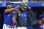 Toronto Blue Jays' Vladimir Guerrero Jr., right, has the home run jacket put on by Teoscar Hernandez, left, after Guerrero's solo home run against the Tampa Bay Rays during the first inning of a baseball game Wednesday, Sept. 14, 2022, in Toronto. (Frank Gunn/The Canadian Press via AP)