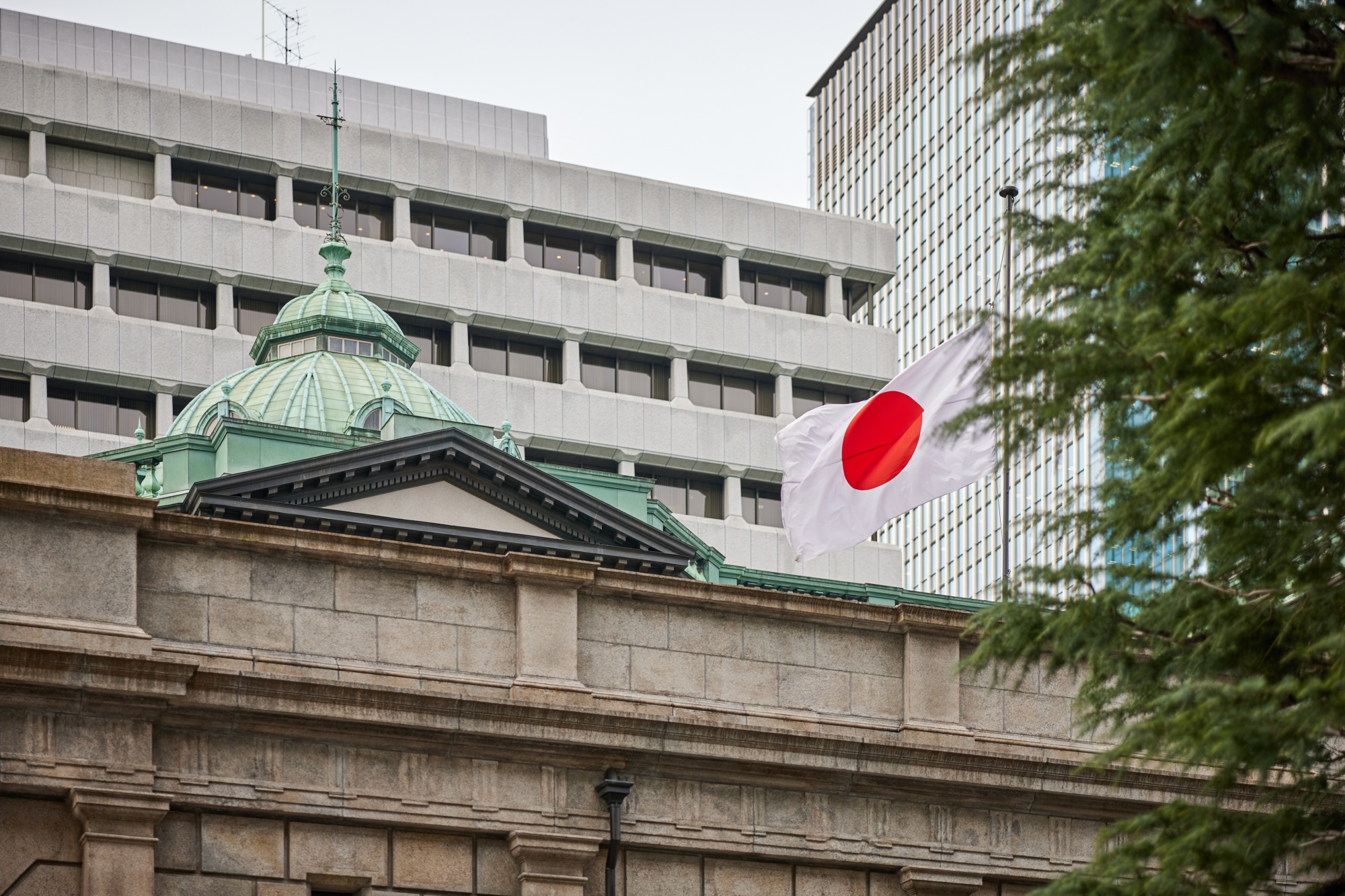 A Japanese flag flies outside the Bank of Japan headquarters, March 14, 2024. 