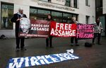 Protesters hold banners in support of Julian Assange outside court in London on Feb. 19.