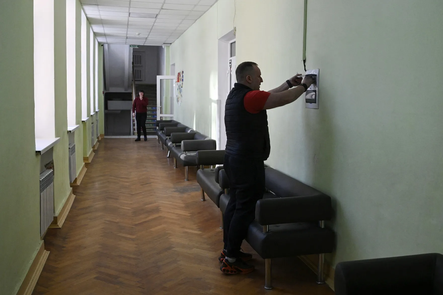 A school headmaster surveys electricity switches in an empty school in Kyiv.