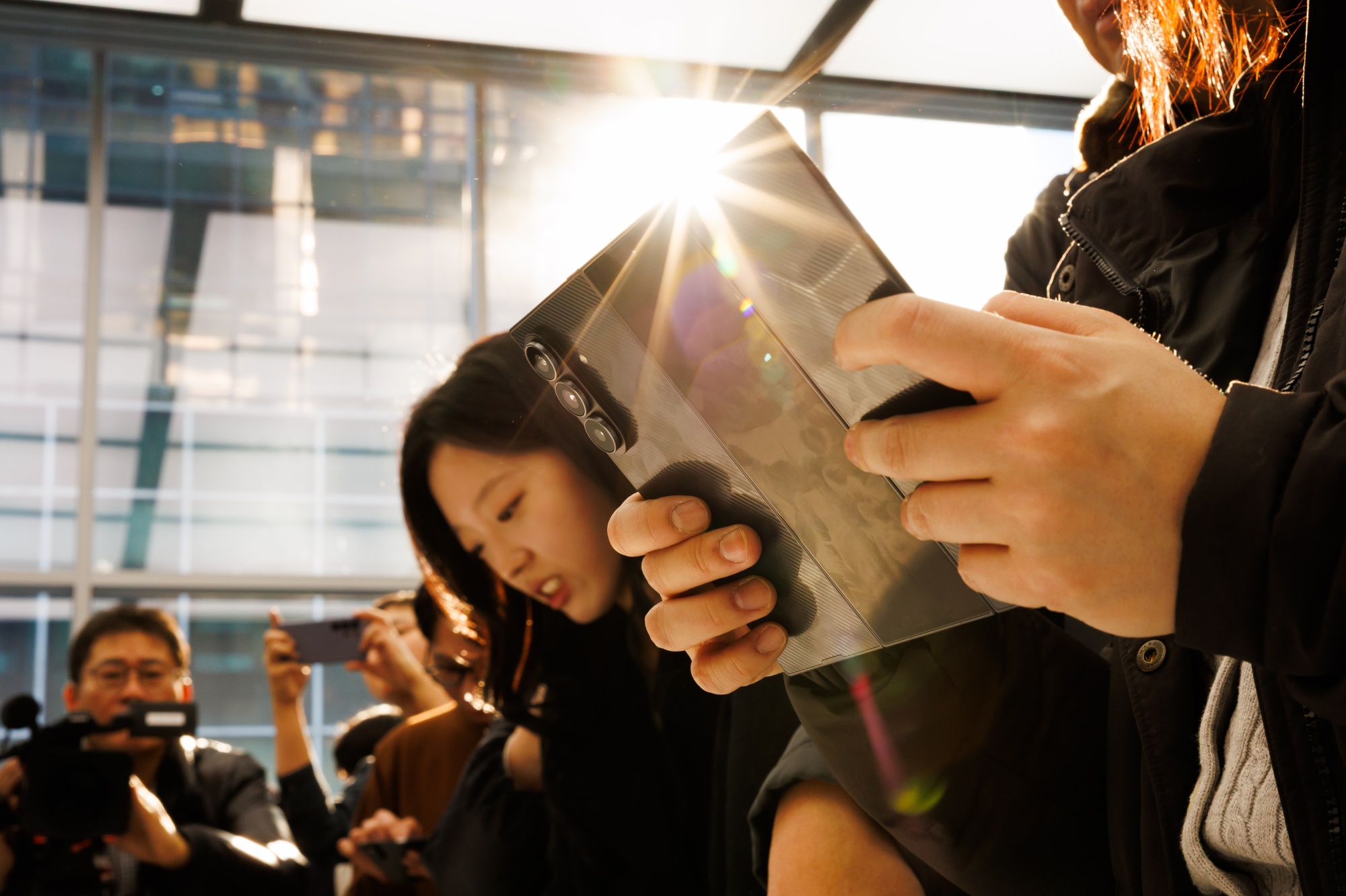 An attendee tries out a Samsung Electronics Co. Galaxy Z Trifold smartphone during a media preview in Seoul, South Korea, on Tuesday, Dec. 2, 2025. Samsung unveiled its first so-called trifold smartphone, flaunting its engineering prowess in foldable devices even as the broader category has yet to catch on with mainstream consumers.