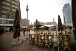 Stacked tables and chairs outside a closed restaurant on Alexanderplatz in Berlin, Germany, on Thursday, Nov. 18, 2021. Just months after people began to return to the office, Germany is poised to agree on mandatory remote working as long as there are no &quot;operational reasons&quot; that stand in the way.