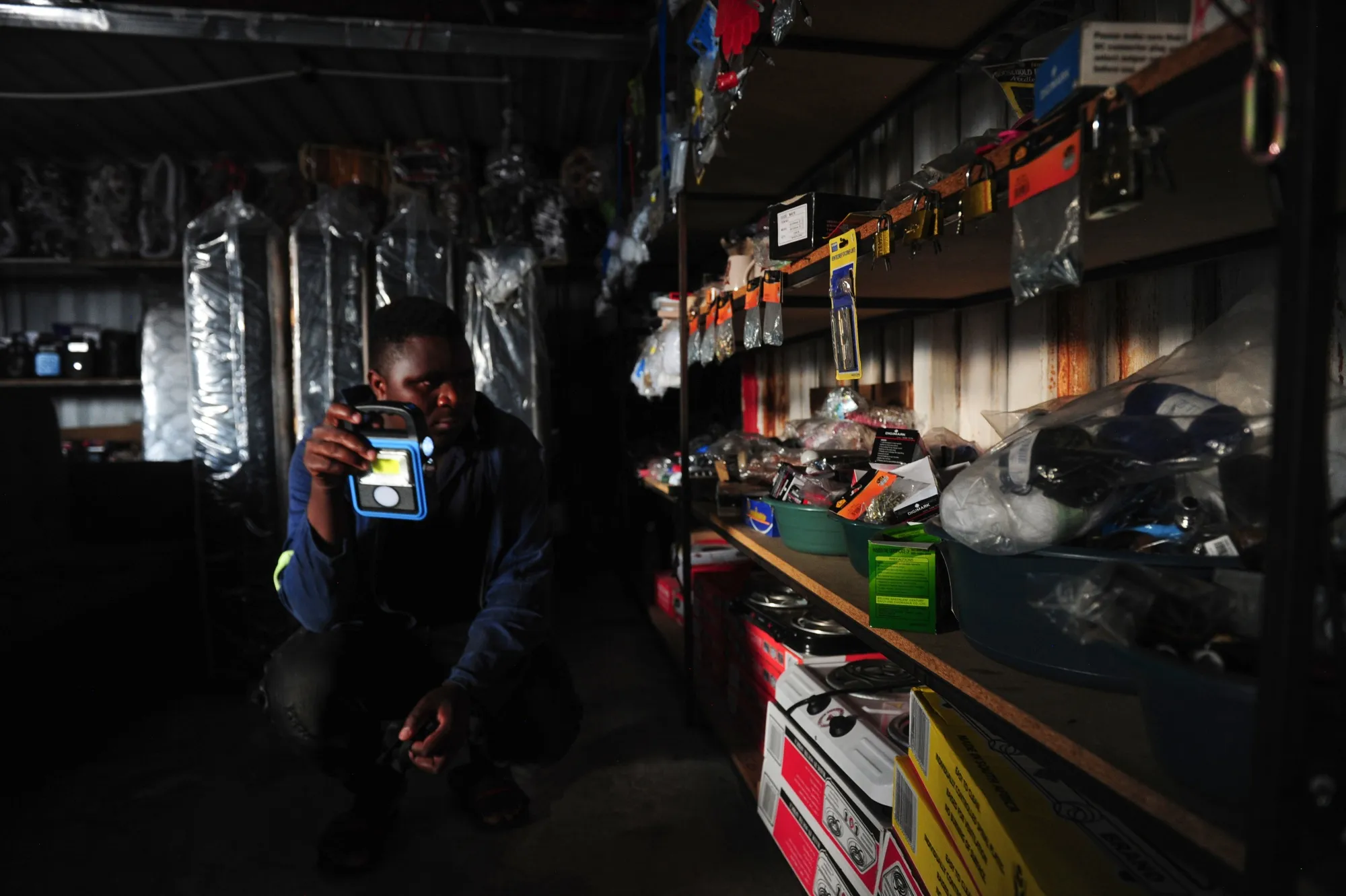 A worker uses a torch inside a hardware store during loadshedding, in Johannesburg, South Africa.