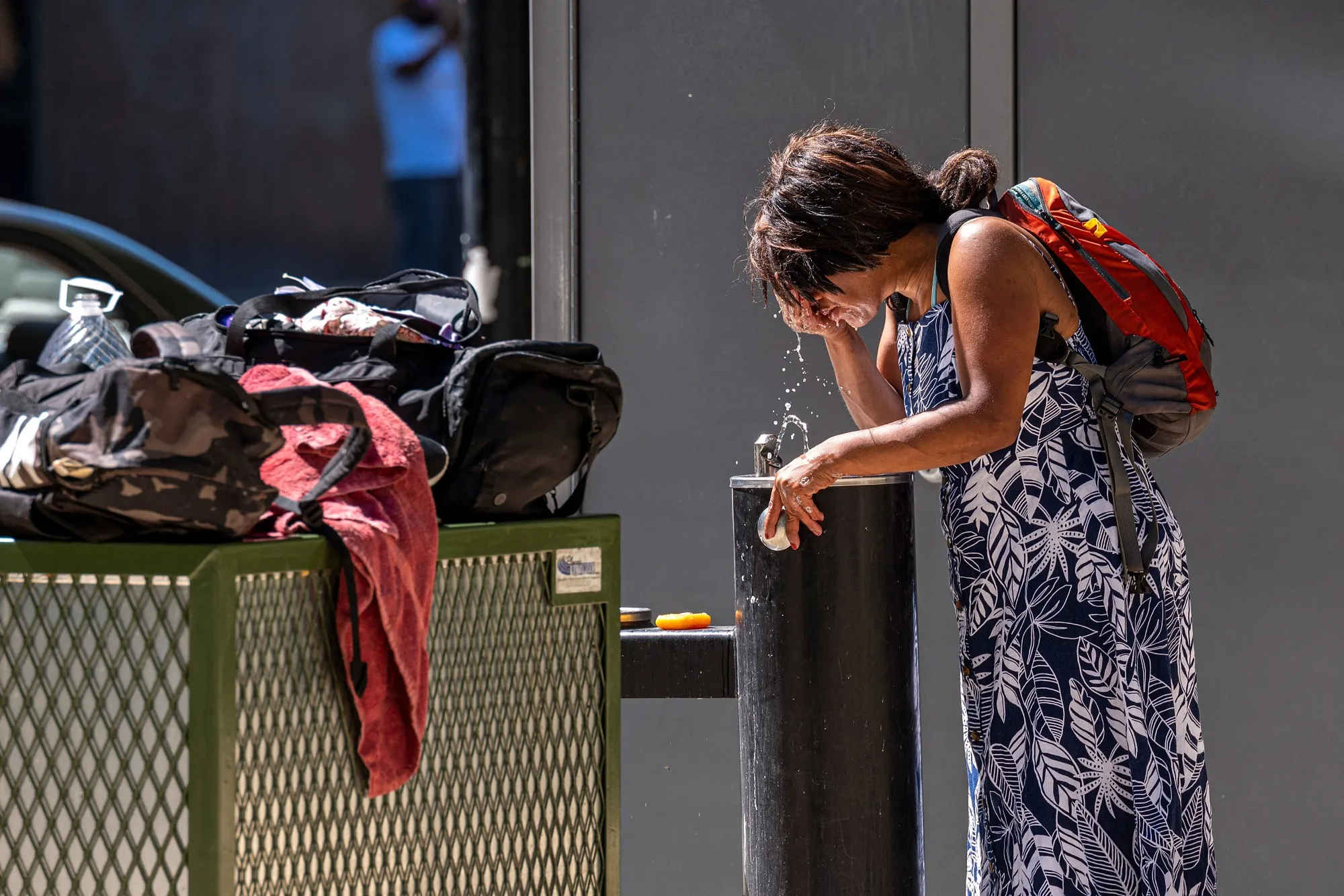 A resident splashes water onto their face during a heatwave in Sacramento, California.