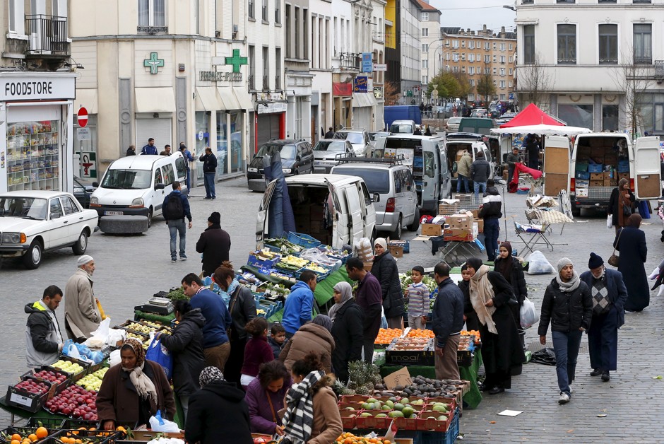 People shop at a market in Molenbeek, Belgium, where police staged a raid following the terror attacks in Paris, on November 15, 2015.