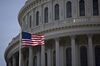 The American flag flies next to the dome of the U.S. Capitol building during rehearsal for the 2017 Inaugural Ceremonies in Washington, D.C., U.S., on Sunday, Jan. 15, 2017. Donald Trump becomes the 45th U.S. president on January 20, the first billionaire to occupy the White House and just the fourth person elected to the office after losing his home state.