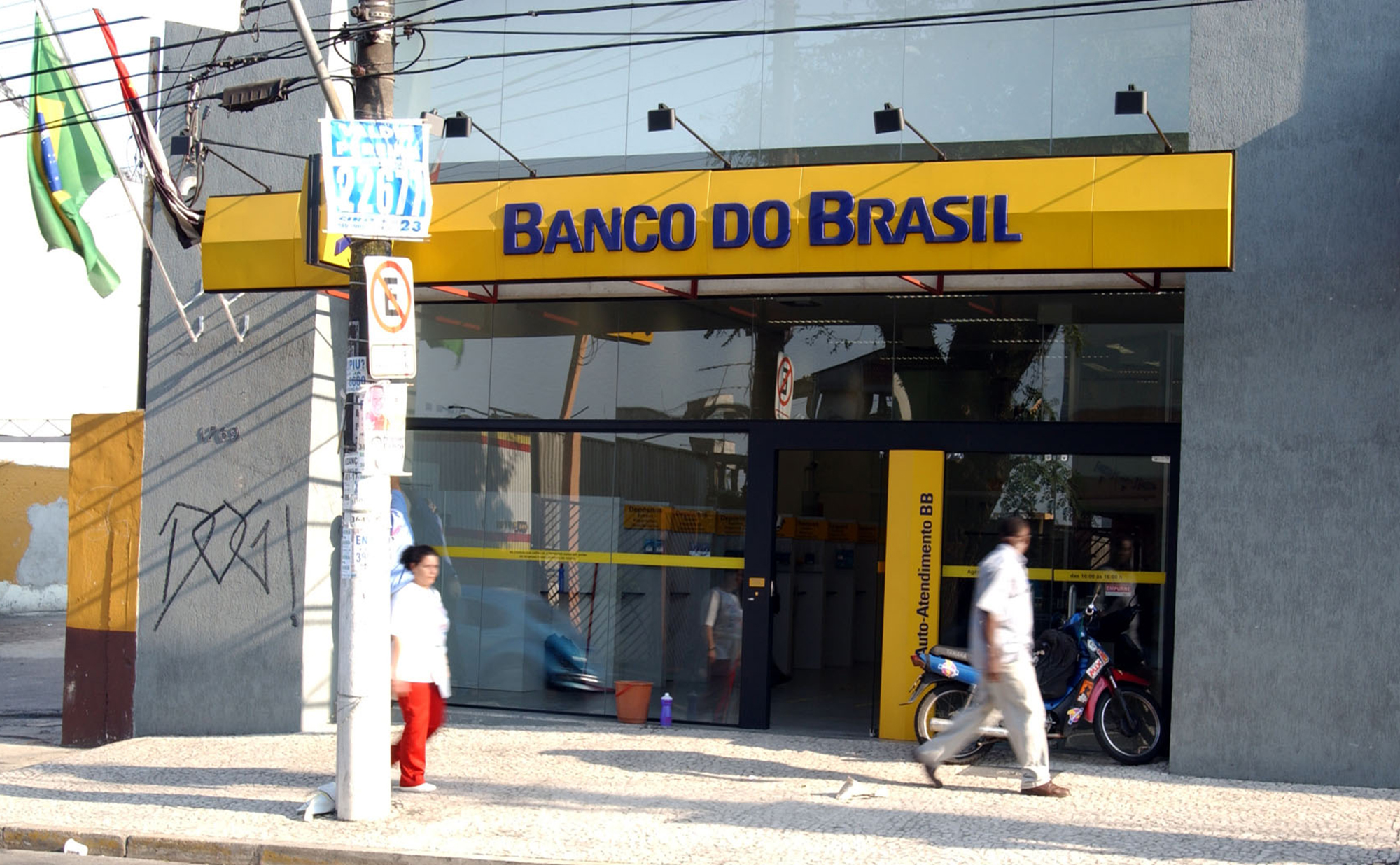 Os pedestres passam por um dos bancos subsidiários do Banco do Brasil em São Paulo.
