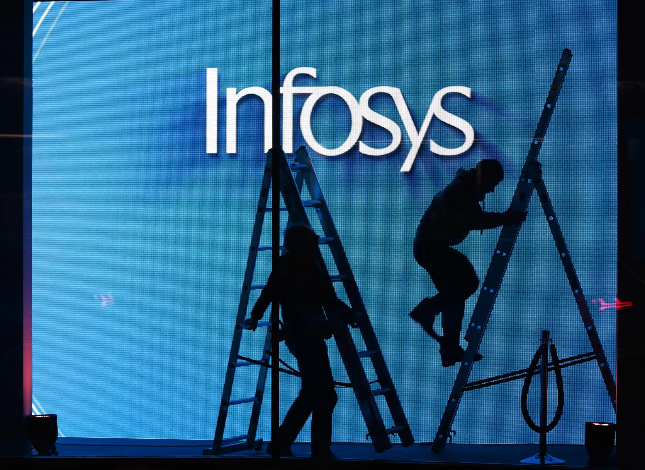 Workmen prepare an electronic screen at an Infosys Ltd. popup venue.
