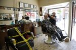A barber cuts a customer's hair in Ottawa on June 12.